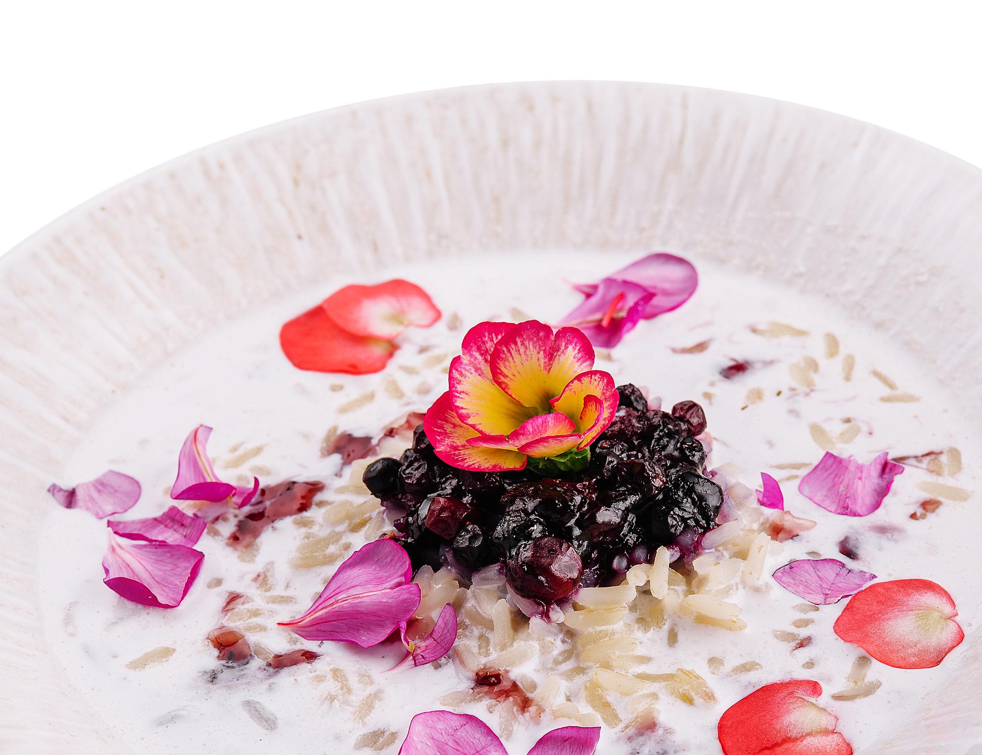 Plating: delikačiai išdėstytas desertas su darželio žiedais